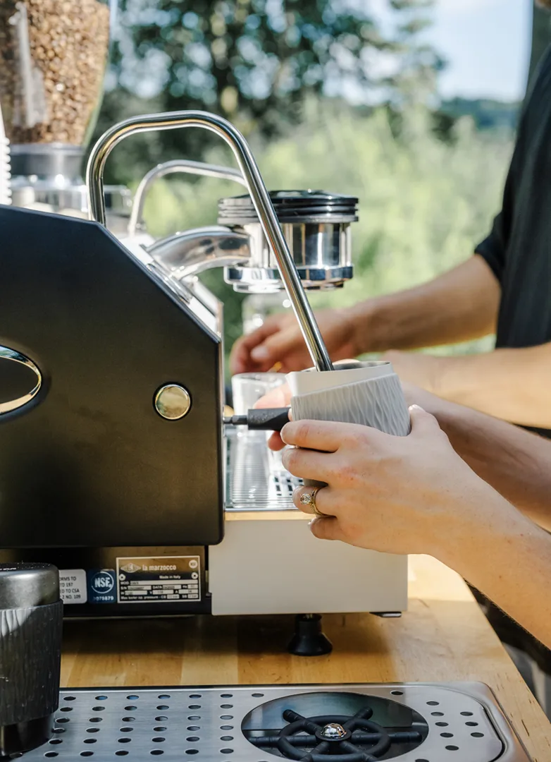 Close-up of a professional barista operating an espresso machine at an event