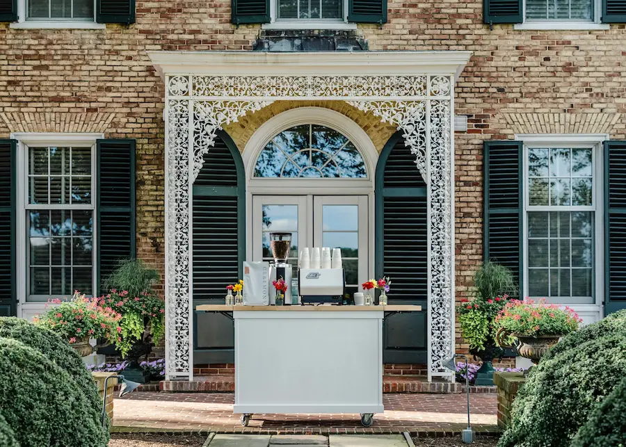 Basileia Coffee Cart espresso bar set up at an estate entrance with fresh flowers
